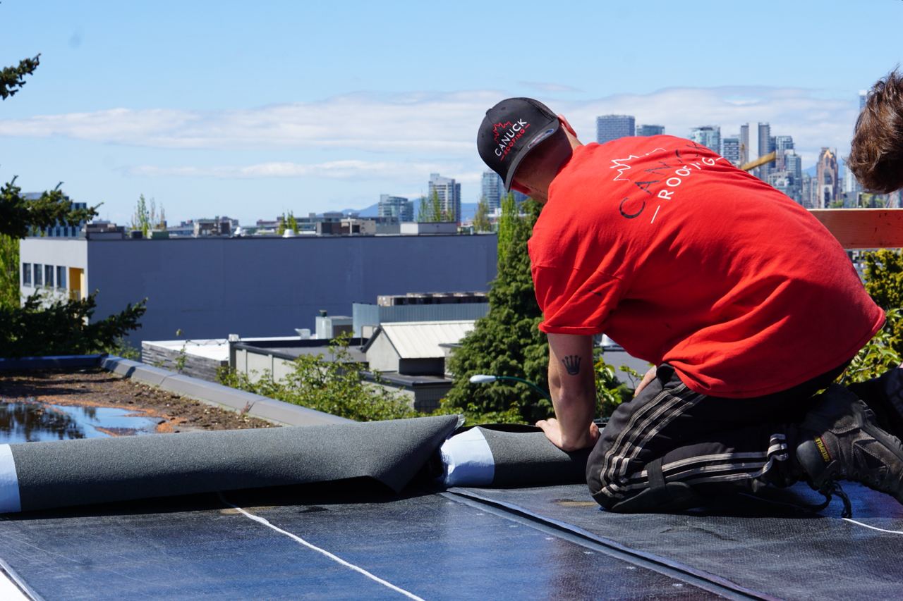 Canuck Roofing crew member installing a torch-on membrane on a Vancouver flat roof